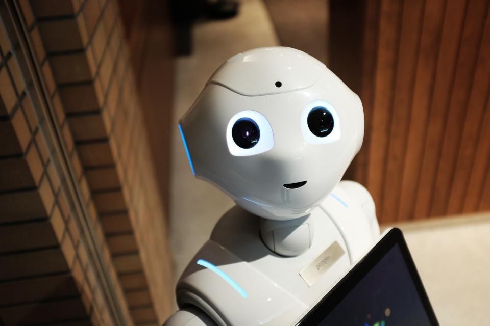 Un robot de servicio con pantalla táctil atendiendo en un mostrador