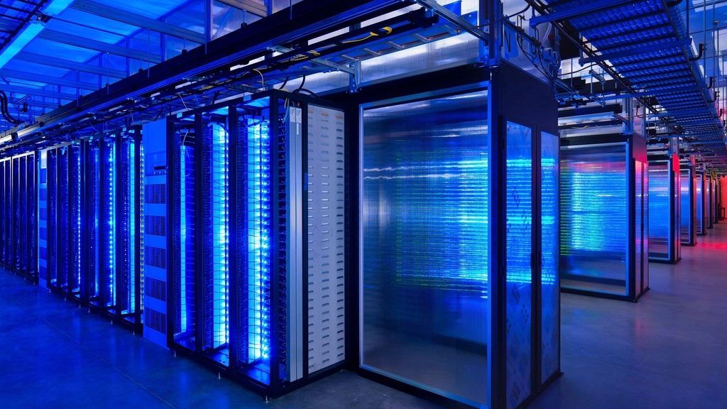 Pasillo de un centro de datos con racks de servidores iluminados